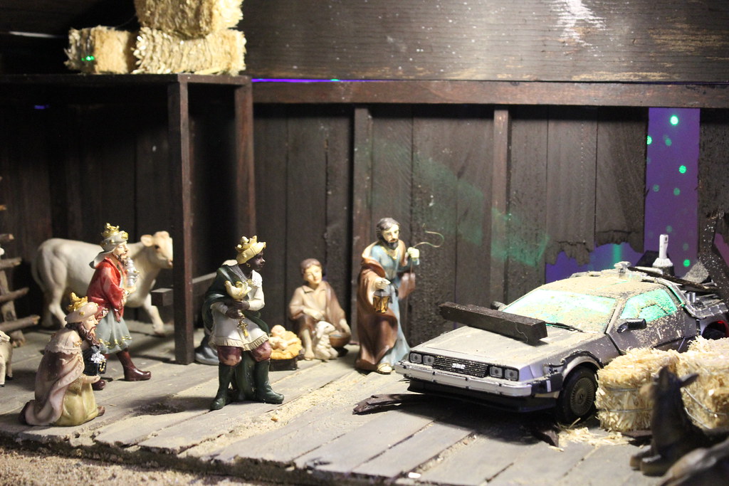 A nativity scene is interrupted by a DeLorean DMC-12, which has crashed through the barn wall.